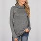 Woman wearing a gray long-sleeve top with buttons on a plain background