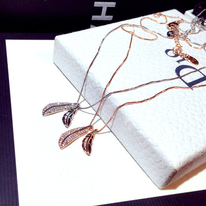 Rose gold necklace with leaf pendants on a white box